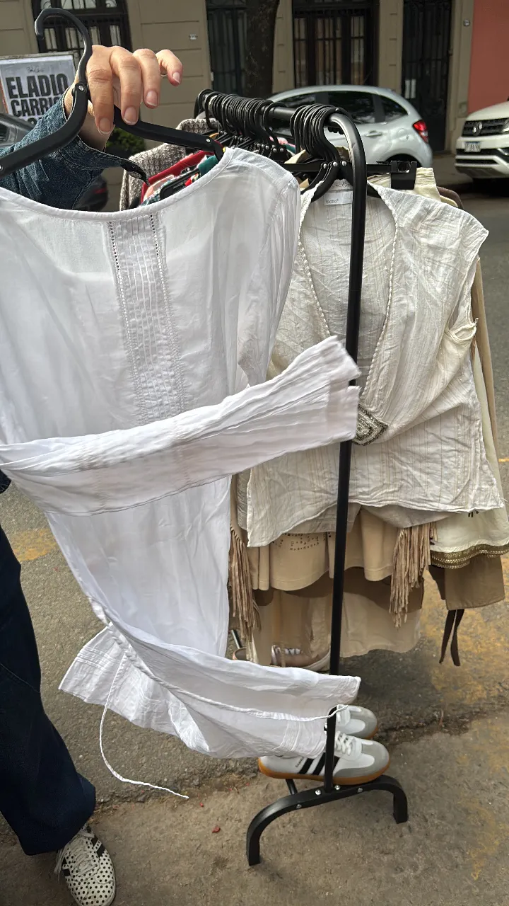 Blusa blanca de algodón con detalles de bordado y puntillas en el escote y mangas. Diseño delicado y fresco, ideal para un look casual y romántico. Las mangas son largas y amplias, con un sutil fruncido.