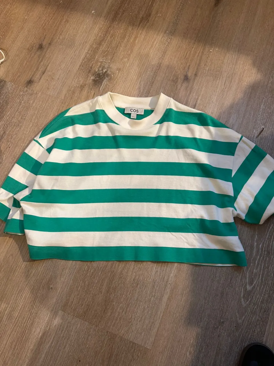 Remera a rayas verdes y blancas, de corte amplio y moderno. Ideal para un look casual y fresco.