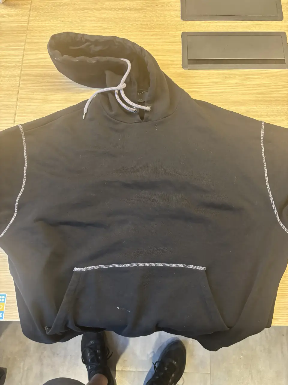 Buzo con capucha negro de hombre, con detalles de costuras en gris claro. Estampado en la espalda con diseño "Cosmos". Ideal para un look casual y urbano.