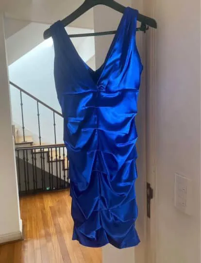 Vestido azul eléctrico, con escote en V profundo y detalles de fruncido que crean un efecto drapeado. Ideal para eventos y fiestas, resalta la figura con su corte ajustado.