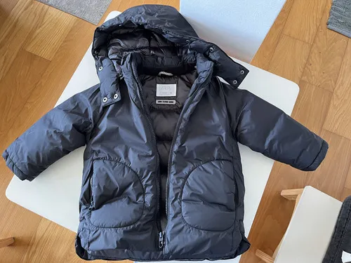 Campera de plumas negra con capucha, ideal para el frío. Perfecta para que los más chicos jueguen al aire libre o para el día a día en invierno. Cierre completo y bolsillos funcionales.