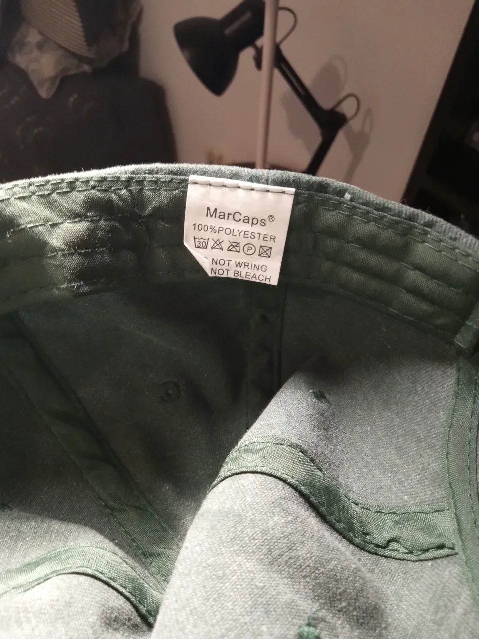 Gorra de color verde oscuro, ideal para protegerse del sol en días de verano o para complementar un look casual.