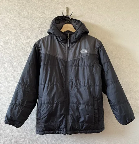 Campera de abrigo acolchada con capucha, ideal para el frío. Diseño moderno en dos tonos de gris, perfecta para un look casual y deportivo.